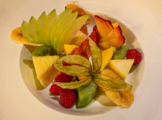 A colorful and refreshing fruit salad featuring a vibrant assortment of freshly cut fruits such as...