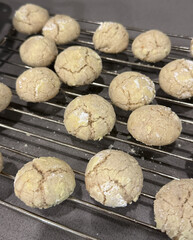 A batch of freshly baked cinnamon crinkle cookies, dusted with powdered sugar, cooling on a wire rack.