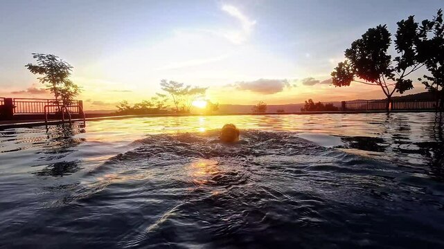backstroke swimming in pool with sunset enjoying summer vacation having fun with ocean view sunset 4k