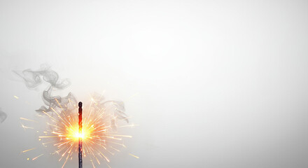 Obraz premium Sparkler igniting with bright flames and smoke on neutral background 