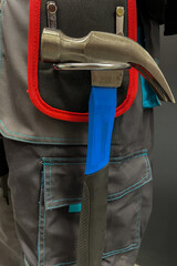 Close-up of tool belt and a hammer on a male construction worker. The concept of repair and construction