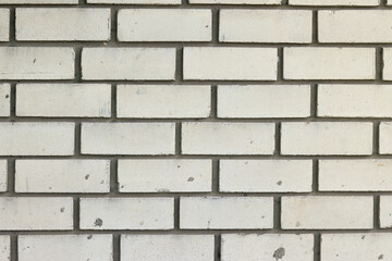 Obraz premium White brick wall, background. Light dirty brick, fence. Close-up of white brick exterior wall. Construction, building, close-up of house element