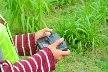 Young Asian woman flying a drone in nature
