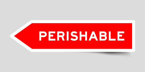 Red color arrow shape sticker label with word perishable on gray background