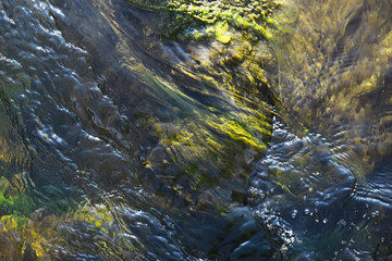 Close-Up of Flowing Water over Moss-Covered Rocks in a Stream