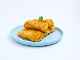 Golden crispy risol mayo stacked on a light blue plate, isolated on a white background