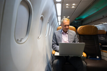 Business trip vacation and travel concept. Caucasian business Man travelling by plane and working...