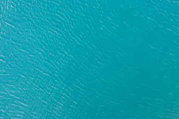 Tranquil blue water surface reflecting sunlight against soft ripples