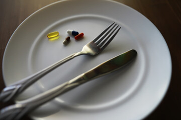 Diet and Medicine Concept: Fork and Knife on Plate with Pills