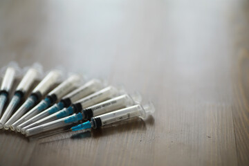 Syringes Neatly Arranged on Wooden Surface Signifying Medical Preparedness and Health Care