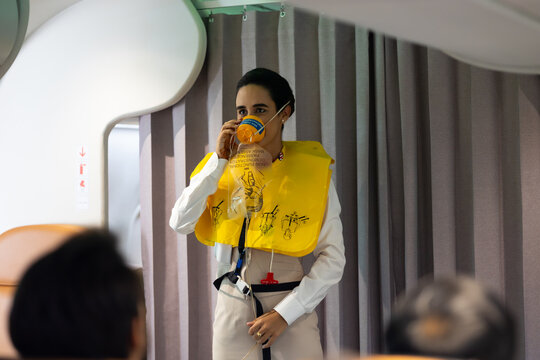 in-flight safety demonstration : Air hostess staff airline demonstrate. Cabin Crew or Steward staff airline demonstrate safety procedures to passengers. Flight attendant