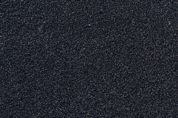 Textured black background with fine grains creating a visually striking appearance