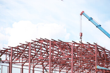 Construction Site with Steel Framework and Crane on a Clear Day Under Blue Sky