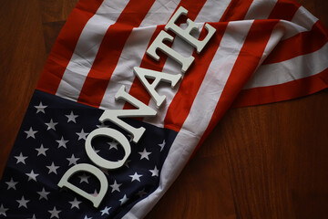 Patriotic Donation Concept with American Flag and Donate Sign on Wooden Background