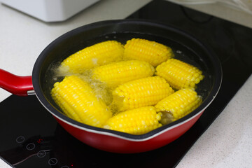 Boiling sweet corn in a pan