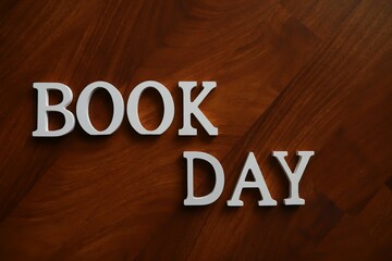 Wooden Letters Forming Book Day on Rich Mahogany Surface