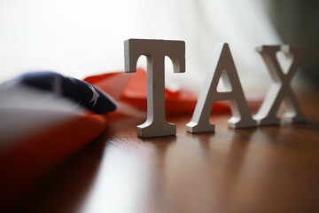 Tax Concept with Wooden Letters and American Flag in Background