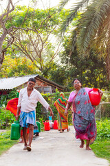 People carrying colorful water containers, returning home after collecting water from a community source in a lush rural 