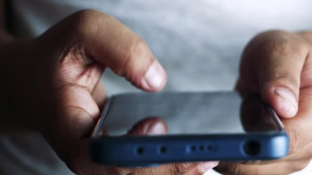 Finger scrolling social media app feed, information search. Keep connected and keep your clients happy. Close up of young scrolling through cell phone social media.