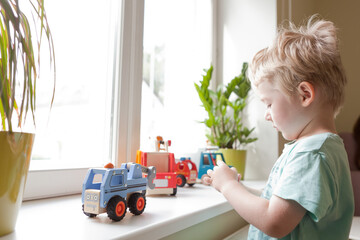 little boy playing with toy car
