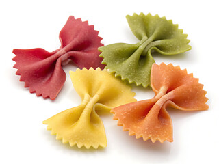 A close up of colorful farfalle pasta arranged on a white surface in a studio setting with bright light