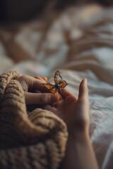 Obraz premium Delicate butterfly resting in cupped hands, conveying a sense of wonder and fragility. Soft light enhances the scene's gentle feel.
