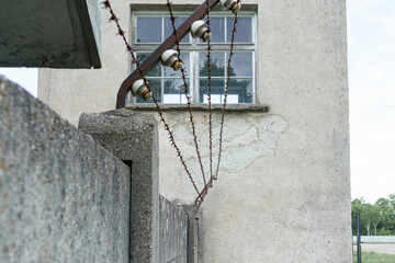 Security measures on building perimeter with barbed wire and window view during daylight