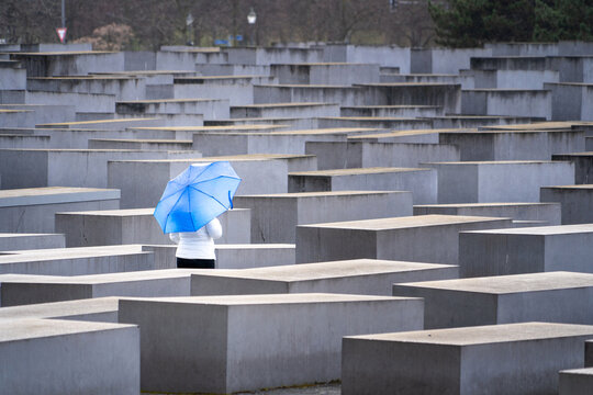 Mujer con paraguas caminando entre los bloques del Memorial al Holocausto en Berl&iacute;n	