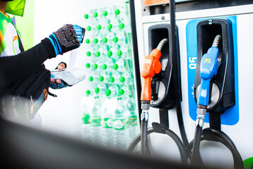 Hand of cashier pull slip from credit card reader with blurry gas station background. Credit card payment. Buy and sell products  service. The concept of payment.
