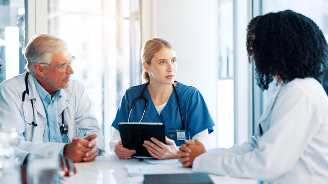Tablet, discussion and team of doctors in hospital boardroom with medical report for treatment planning. Digital technology, research and group of healthcare workers with surgery schedule in clinic.