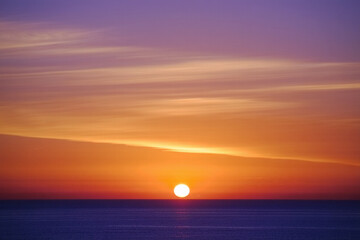 Beautiful sunset reflecting over the sea with orange sky and gentle waves