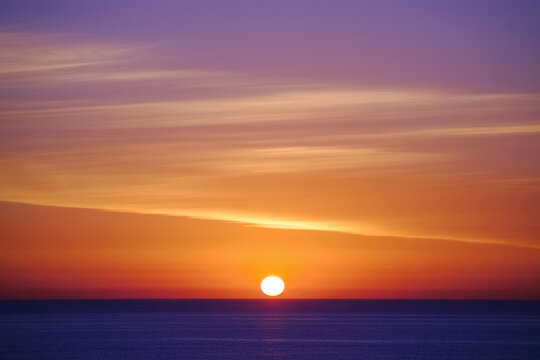 Beautiful sunset reflecting over the sea with orange sky and gentle waves