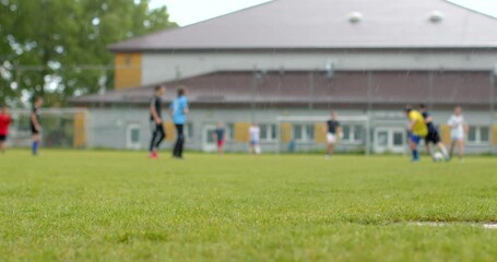 A group of enthusiastic youth soccer players is training on a grassy field near a community sports facility, practicing drills for an upcoming game and honing their skills - Powered by Adobe
