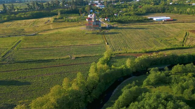 Aerial views showcase a stunning church surrounded by lush landscapes in Ajaria, Georgia. The architecture reflects local history and cultural significance, nestled in a picturesque setting.