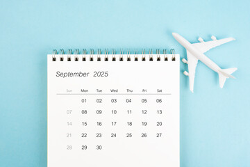 September 2025 calendar and airplane toy on blue background, Travel plan concepts.