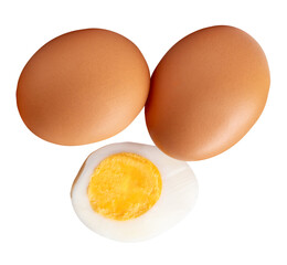 Top view of raw brown chicken eggs and cooked or boiled chicken egg with egg yolk in half isolated on white background with clipping path