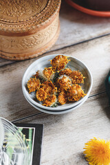 Roasted dandelion flowers. Roasted yellow flowers of a dandelion on a plate. Dandelion flower tea. Dried dandelion flowers