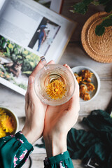 A girl holding a cup of herbal tea. Dandelion flower tea. A cup of  dandelion flower tea.