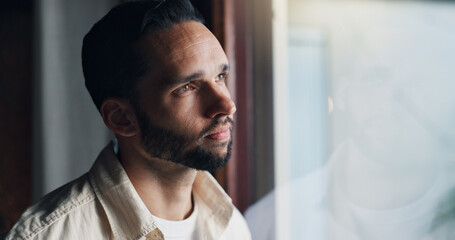 Naklejka premium Thinking, morning and sad with man at window of living room for reflection, mental health and anxiety. Worry, memory and future with male person at home for vision, grief crisis and depression