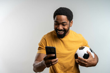 Handsome happy excited African man celebrating in euphoria mood after winning a bet, holding a...