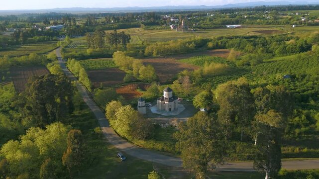 Aerial views showcase a stunning church surrounded by lush landscapes in Ajaria, Georgia. The architecture reflects local history and cultural significance, nestled in a picturesque setting.