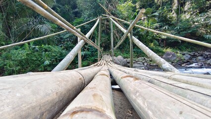 Bamboo Bridge Spanning a River in a Lush Jungle