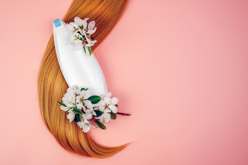 Shampoo, hair conditioner in a white jar on a pink background. Mockup, space for text. Sakura flowers. Shampoo for normal hair, nutrition and protection with flower extracts