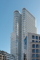 Obraz premium Low angle exterior view of the modern white curved Upper West tower and office buildings against a clear blue sky near Zoologischer Garten in Berlin Germany. 