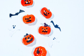 Halloween frame with party decorations of pumpkins, bats, ghosts, spiders on blue background from above. Happy halloween card in flat lay style.