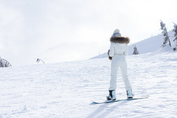 Woman snowboarder on the slopes on a frosty winter day