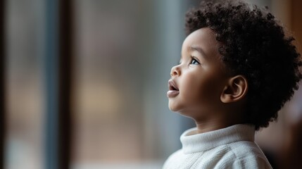 A young child with curly hair, lost in wonder as they gaze out of the window, capturing the innocence and curiosity of childhood in a moment of reflection and tranquility.