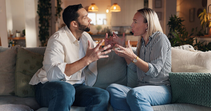 Home, sofa and couple with conflict in marriage, toxic relationship and disagreement for divorce. Night, man and sad woman with fight for separation, breakup and communication problem in living room - Powered by Adobe