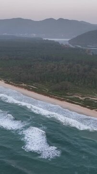 Florianopolis in Santa Catarina during a wonderful sunrise. Mo&ccedil;ambique Beach in aerial view, vertical video.