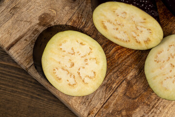 ripe purple eggplant sliced across with small seeds inside, ripe purple delicious eggplant sliced across the fruit on the kitchen table